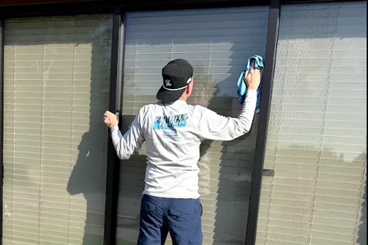 A Faithful Finish team member cleaning commercial storefront windows